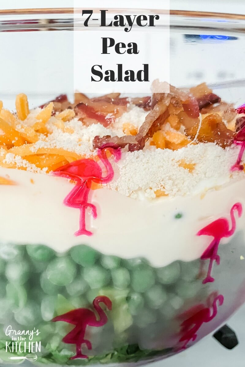 close up of a layered pea salad in glass bowl