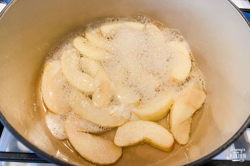 cooking apple slices in pan on stove