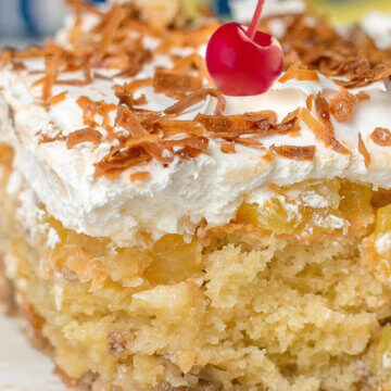 close up of piña colada cake with pineapple and whipped cream