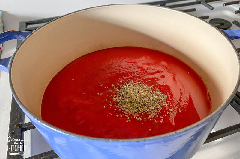 making tomato sauce in blue pot