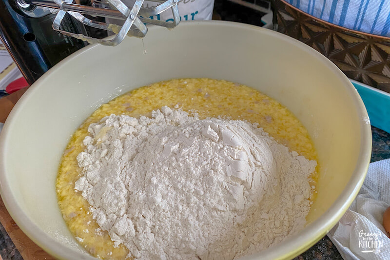 adding flour to dinner roll dough