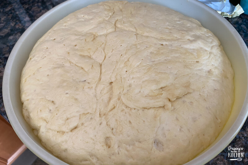 bred dough that's risen in bowl ready to bake