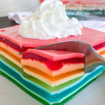 cutting into rainbow layered jello ribbon salad