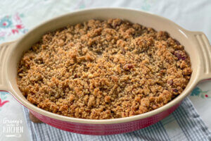 sweet potato casserole with pecan topping in red baking dish