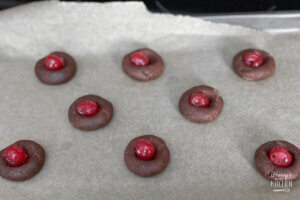 putting maraschino cherries in the middle of chocolate cookies