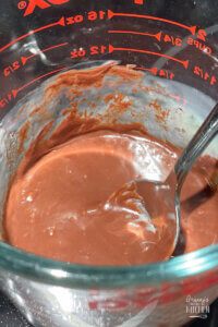 chocolate frosting in glass measuring cup