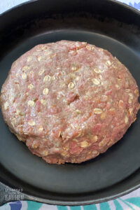 round meatloaf in skillet, ready to cook