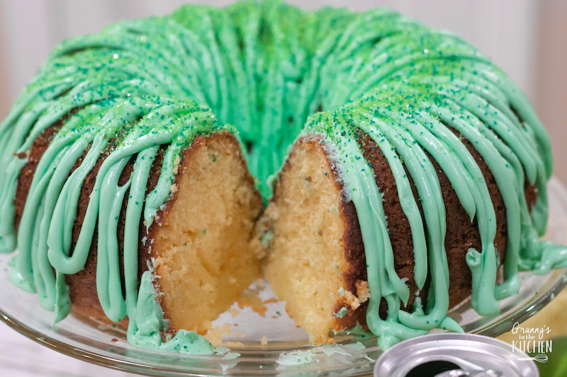 green iced bundt cake with slice missing