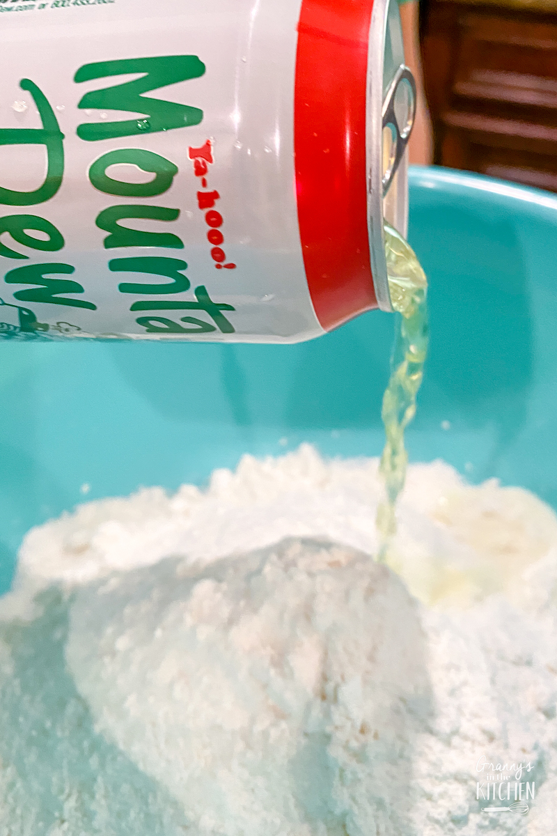pouring Mountain Dew into mixing bowl with cake mix