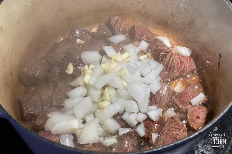 cooking beef cubes and diced onions in large pot