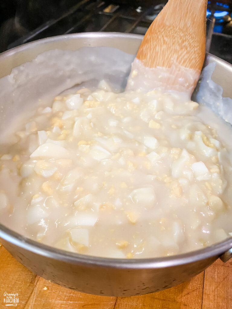 mixing chopped eggs into flour gravy