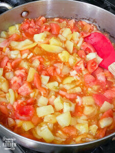 cooking chopped tomatoes in saucepan