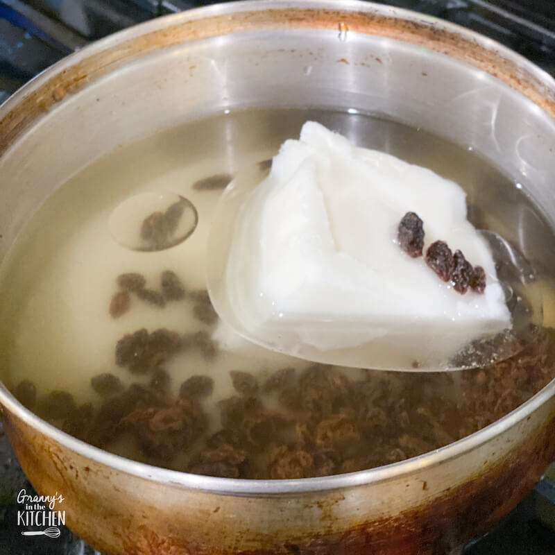 cooking lard, raisins, and water in saucepan