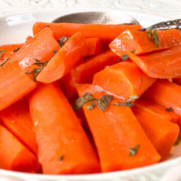 bowl of honey glazed carrots with fresh herbs