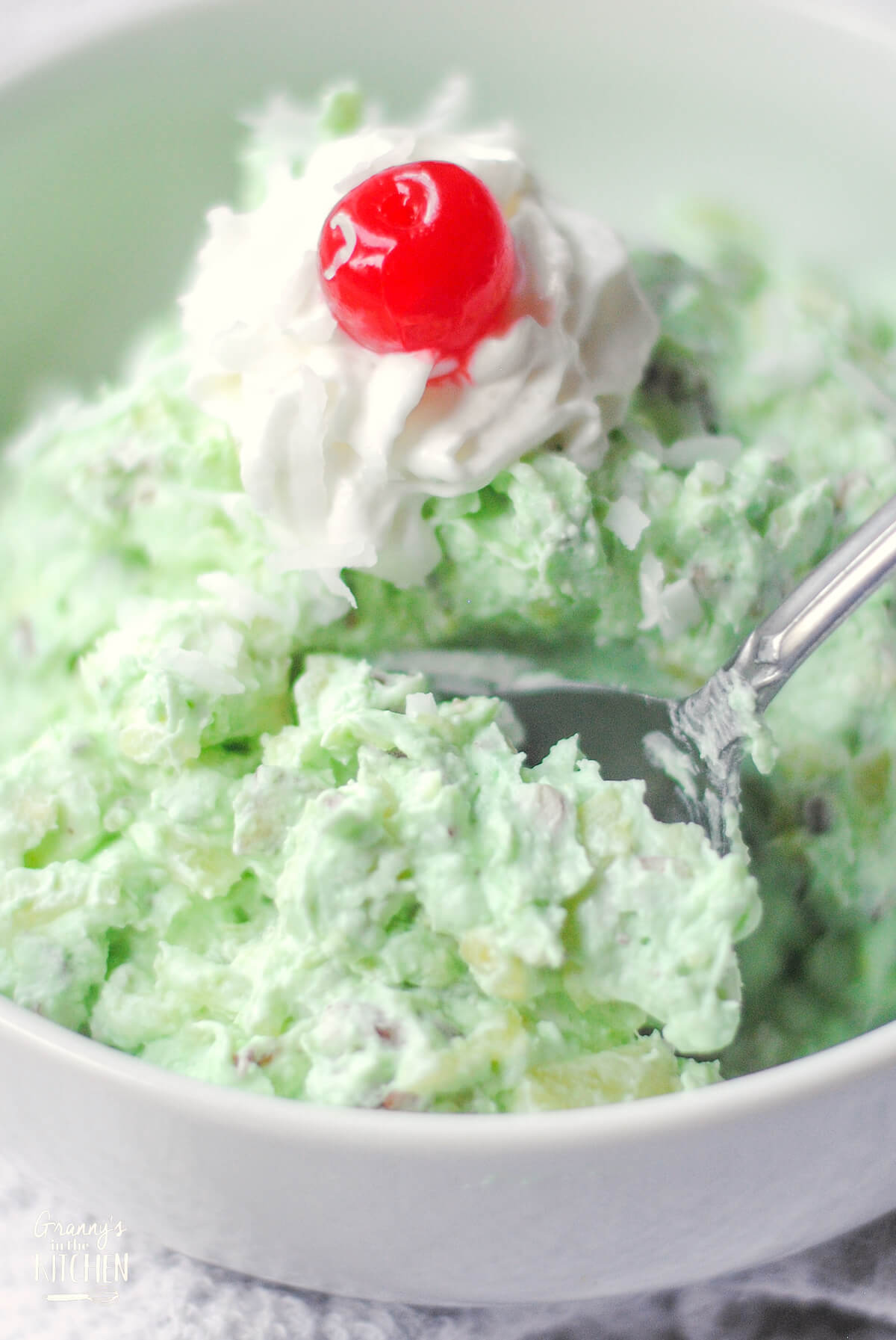 bowl of fluffy green Watergate Salad with serving spoon