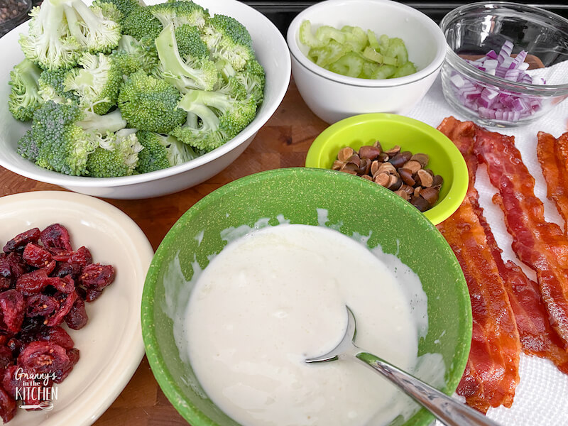 bowls of broccoli and ingredients to make a salad