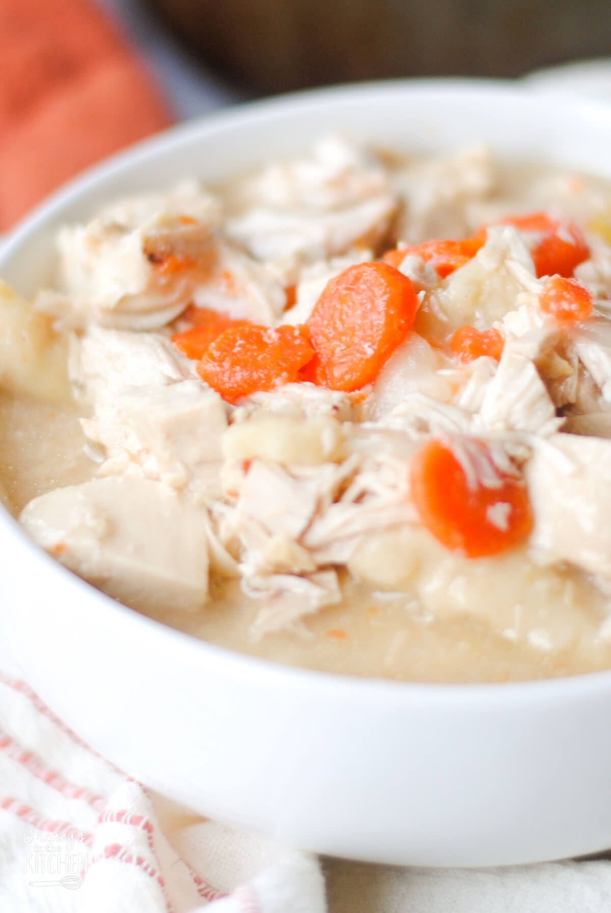 bowl of homemade chicken and dumplings with carrots