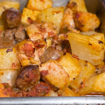 metal baking pan with roasted chicken, Italian sausage, and potatoes