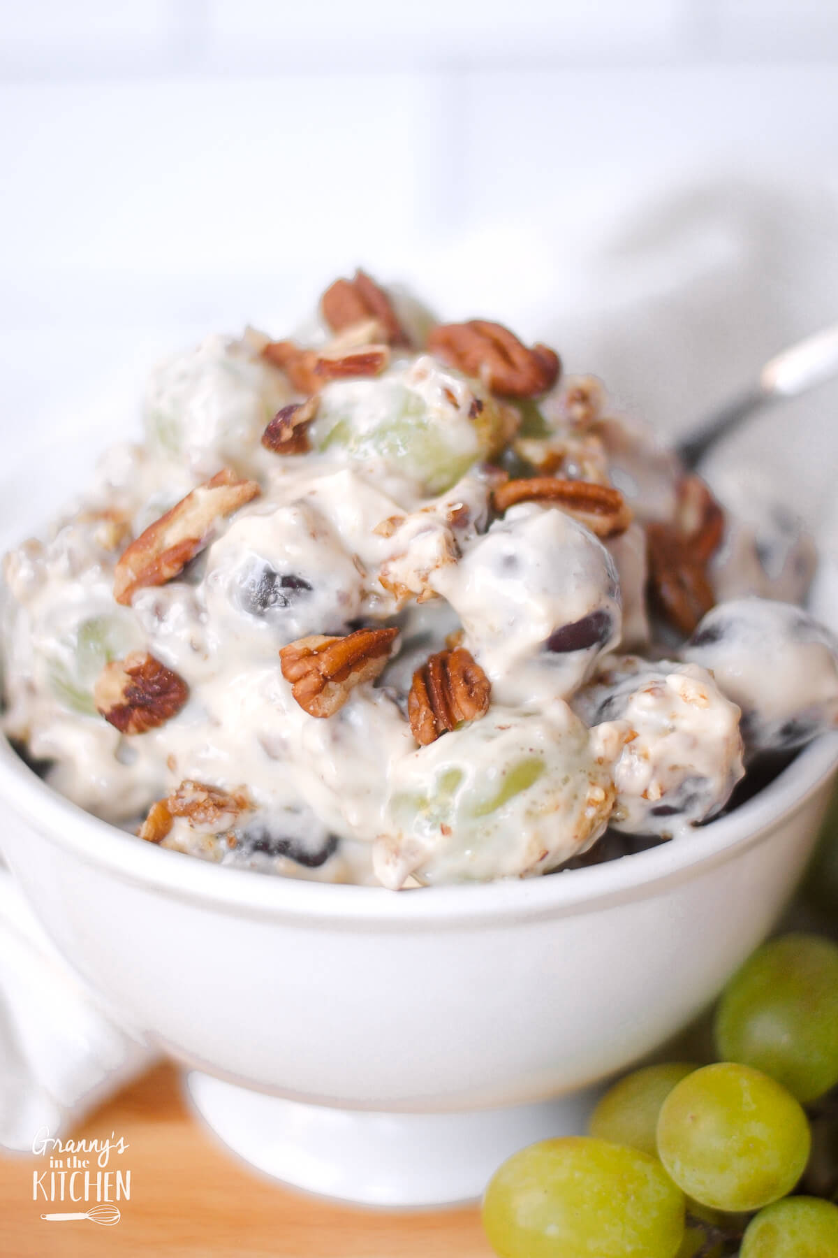 bowl of creamy grape salad with pecan topping