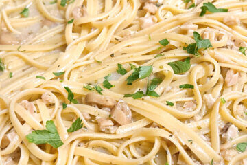 pan of cooked pasta with parsley; text overlay "Linguine with White Clam Sauce"