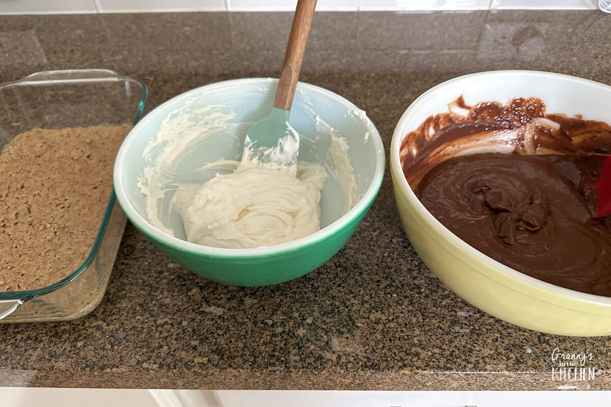 three dishes containing ingredients to make chocolate delight dessert