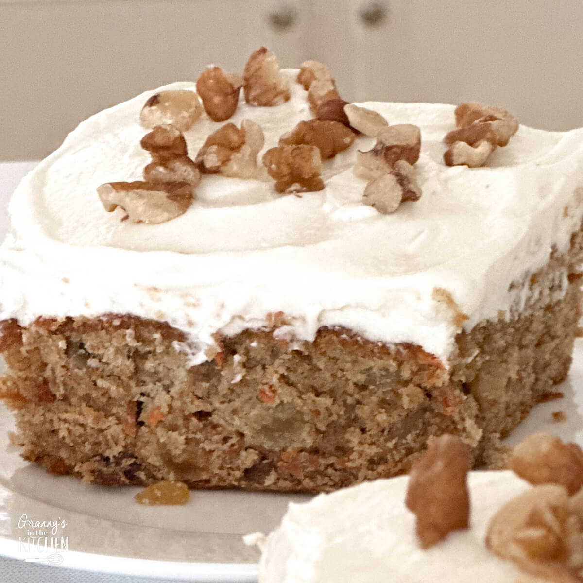 one slice of carrot cake, with cream cheese icing and pecans