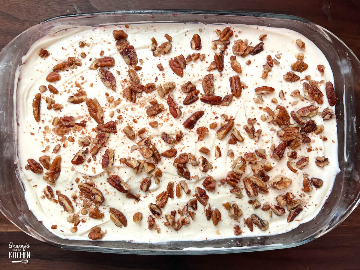 top down view of a jello fluff salad topped with chopped pecans