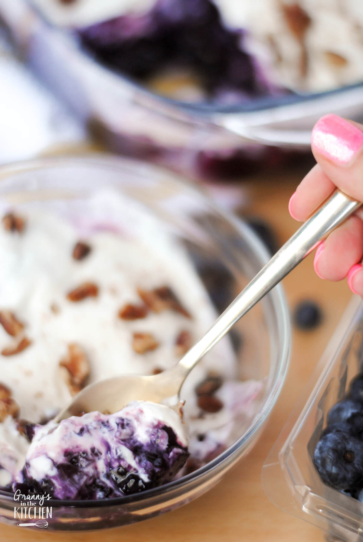 close up of a bowl of blueberry gelatin salad, with a spoonful in front