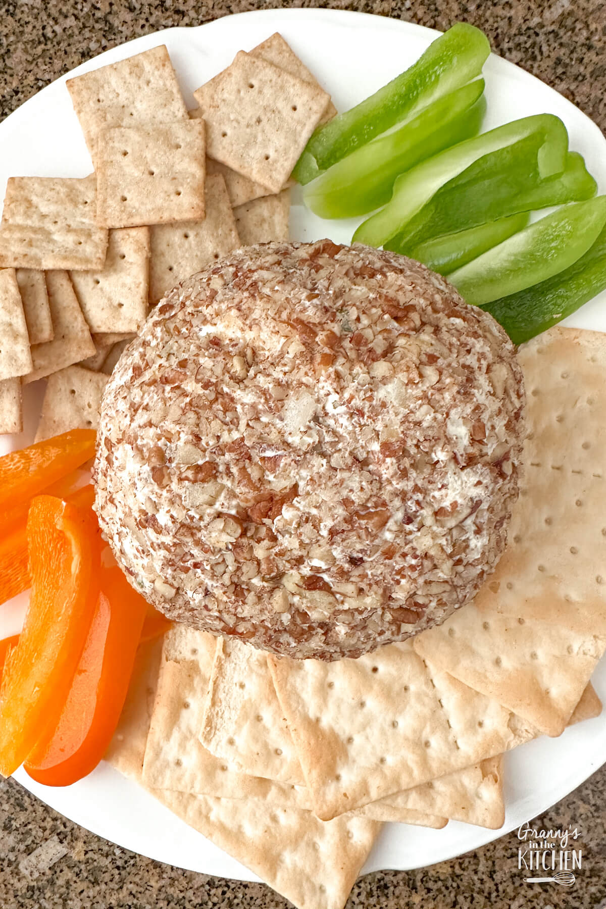 top down view of a pecan crusted cheeseball served with fresh veggies and crackers