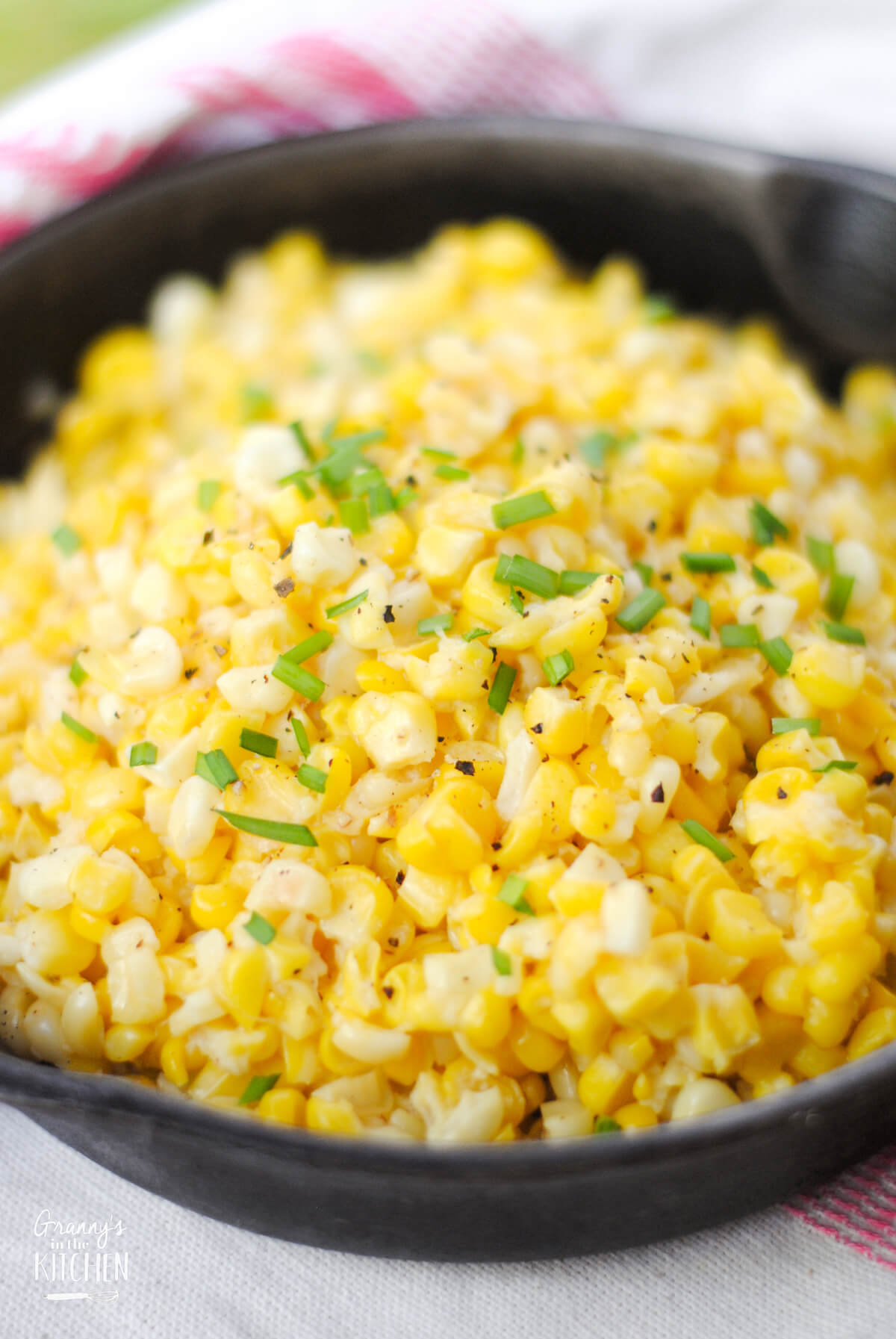 close up of a cast iron skillet filled with cooked corn, to show detail