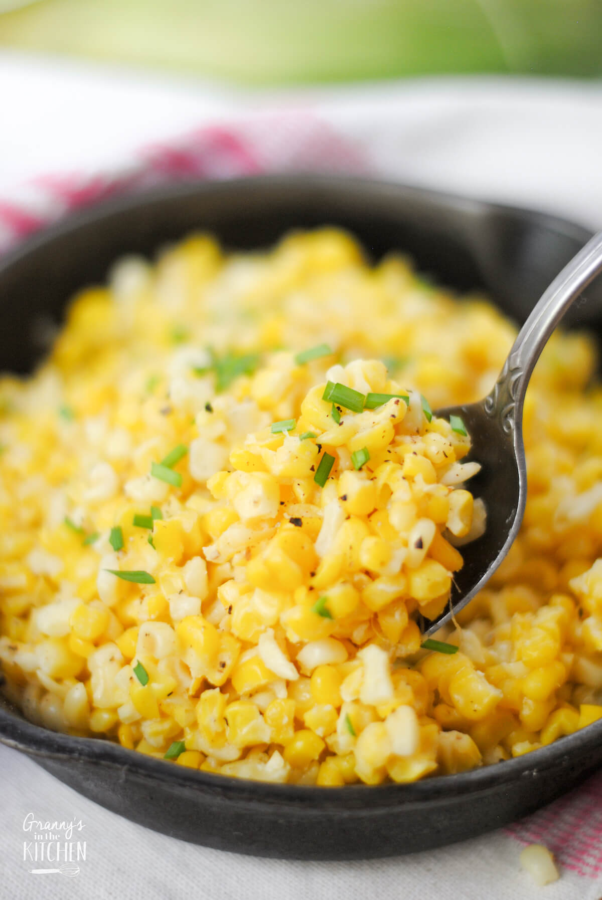 scooping up corn with a spoon, from a skillet