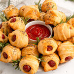 mini pigs in a blanket arranged on a serving platter to look like a wreath