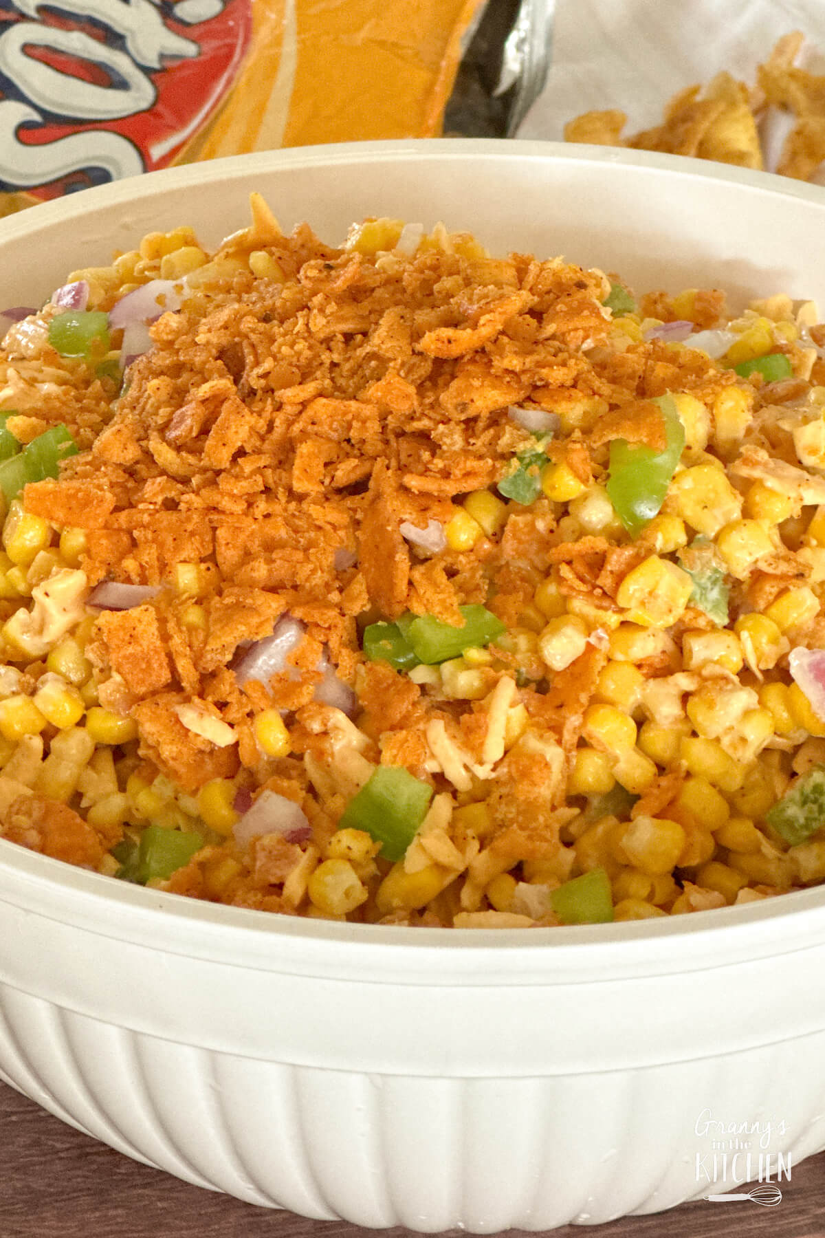 big bowl of corn salad topped with Frito corn chip crumbs.