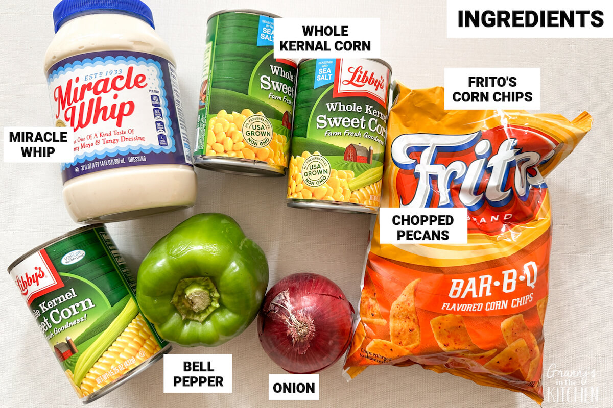ingredients to make Frito corn salad, with text labels: Whole kernel corn, bell pepper, Miracle Whip, onion, Fritos.