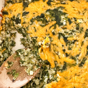 spinach rice casserole with a wooden serving spoon.