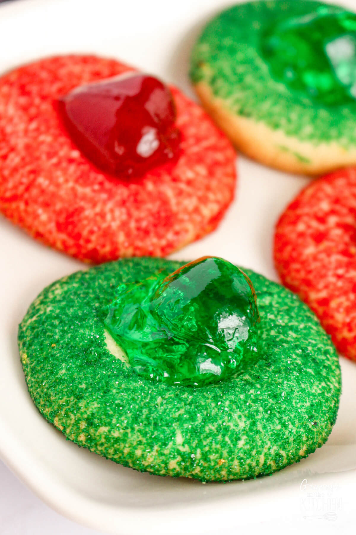 close up of red and green Christmas thumbprint cookies.
