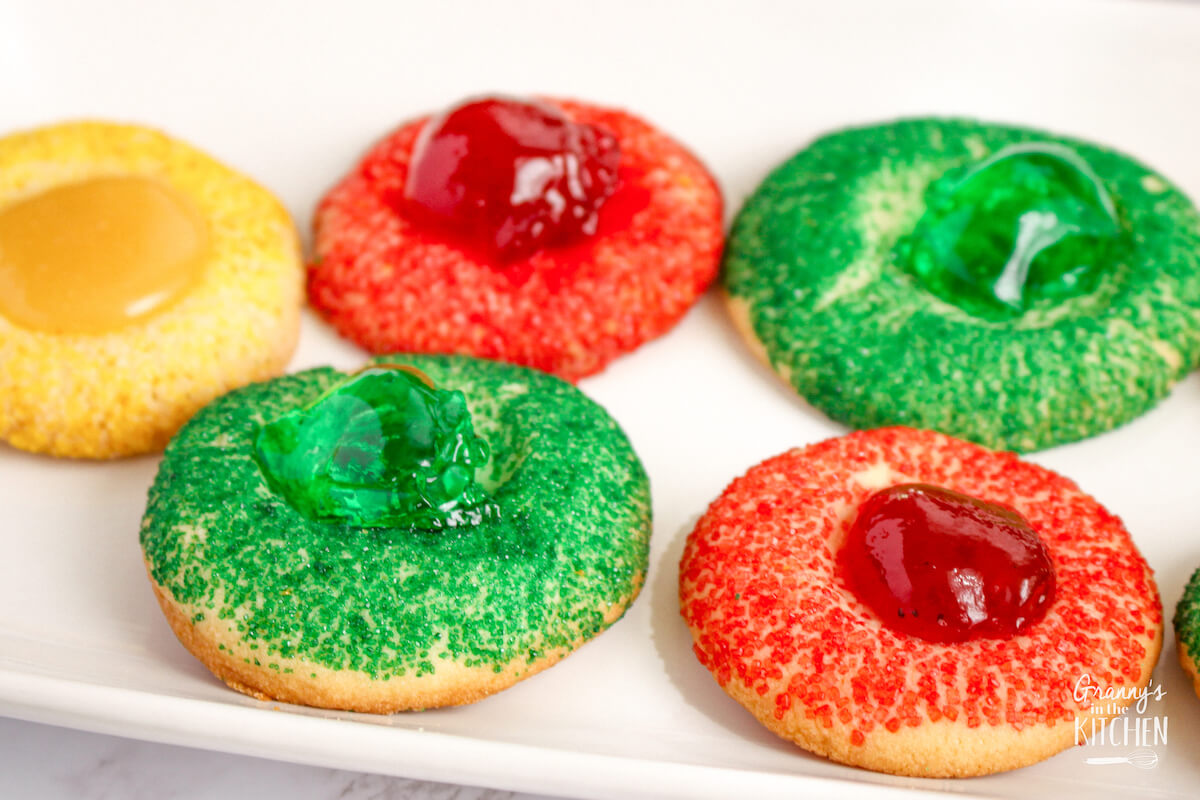 red, green, and gold thumbprint cookies on a white platter.