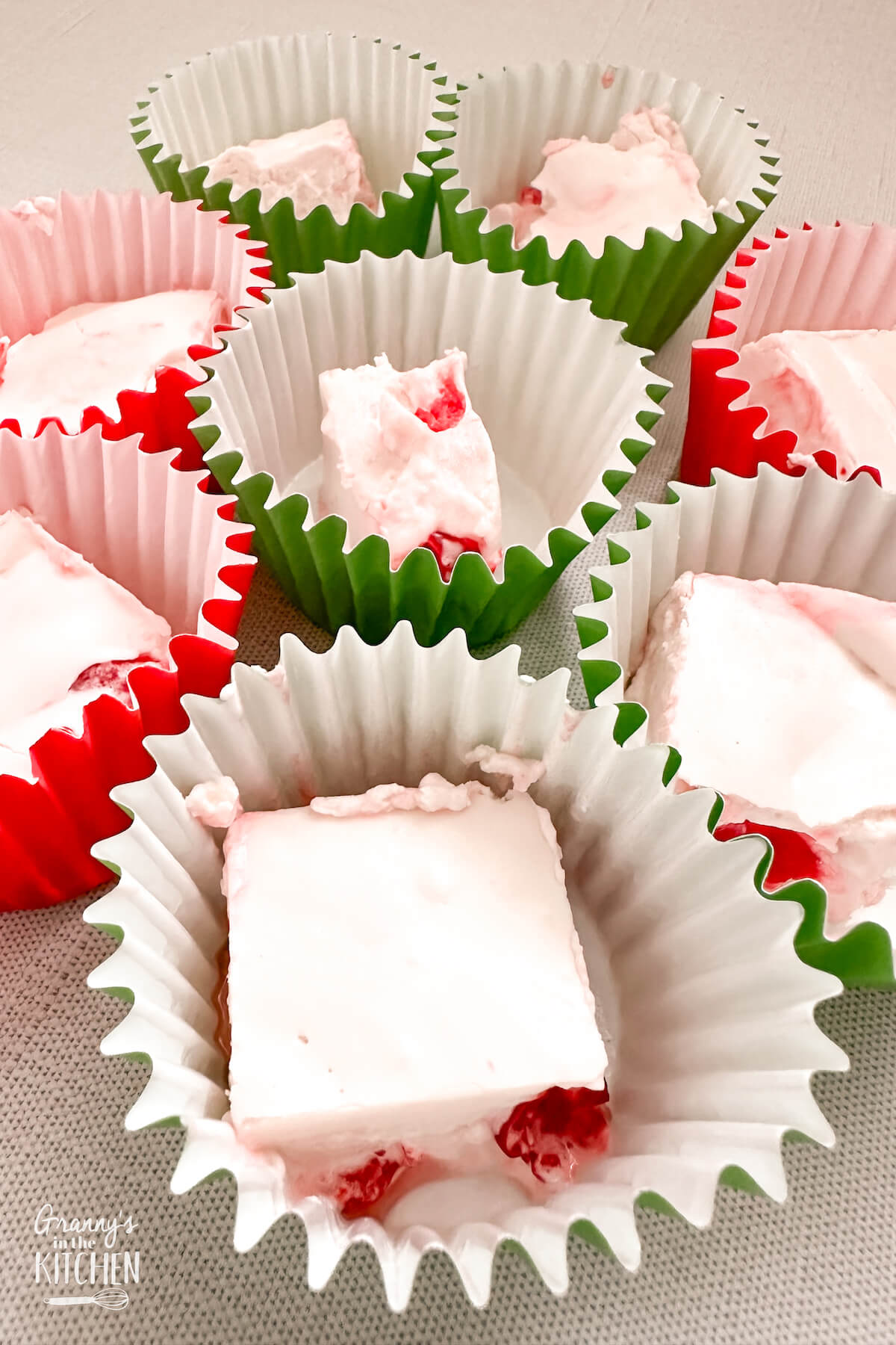squares of cherry divinity candy, in cupcake liners.