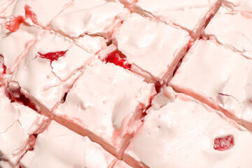 cherry divinity candy, cut into squares, on parchment paper.
