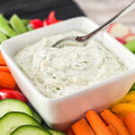 bowl of dill dip surrounded by fresh veggies.