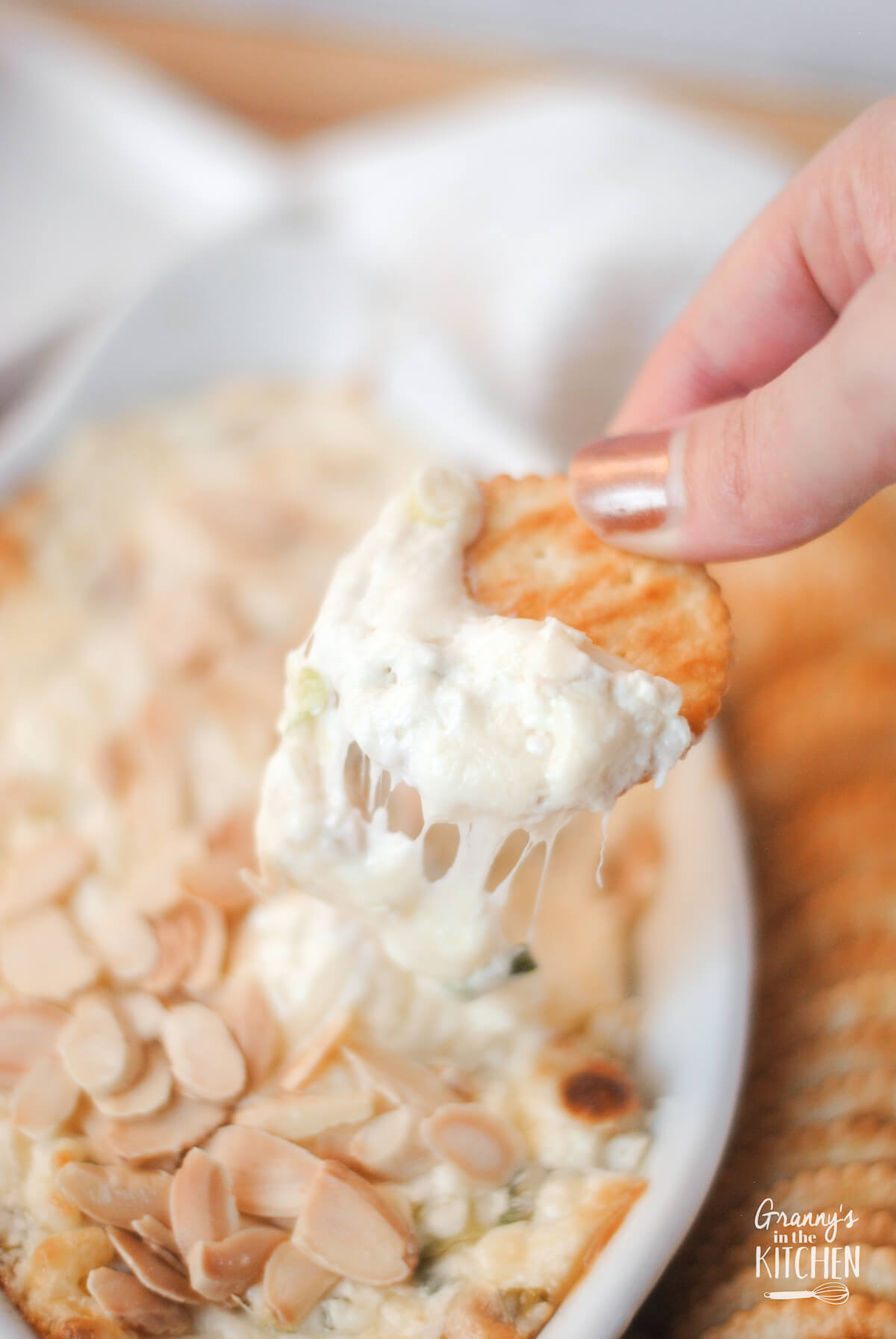 dipping a Ritz cracker into melted Swiss cheese dip.