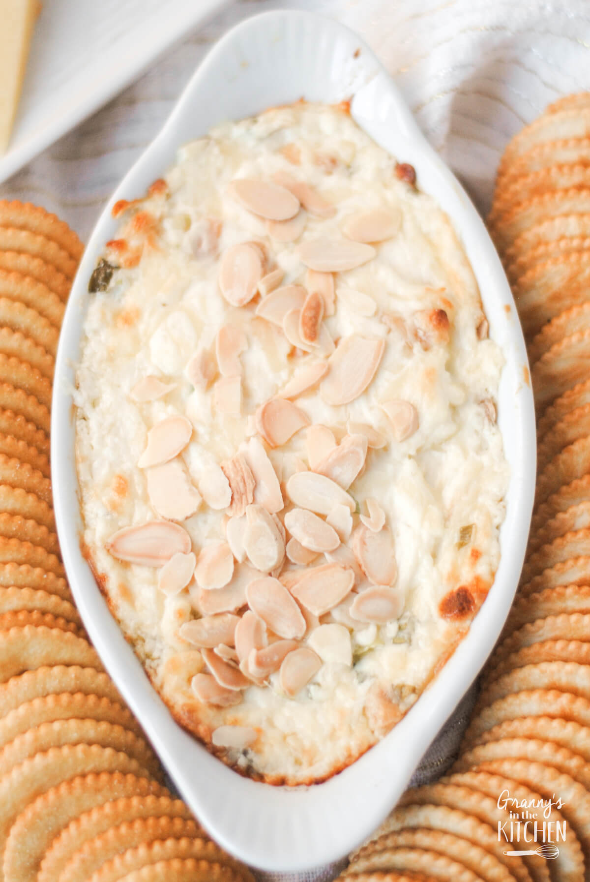baking dish with Swiss almond dip surrounded by Ritz crackers.