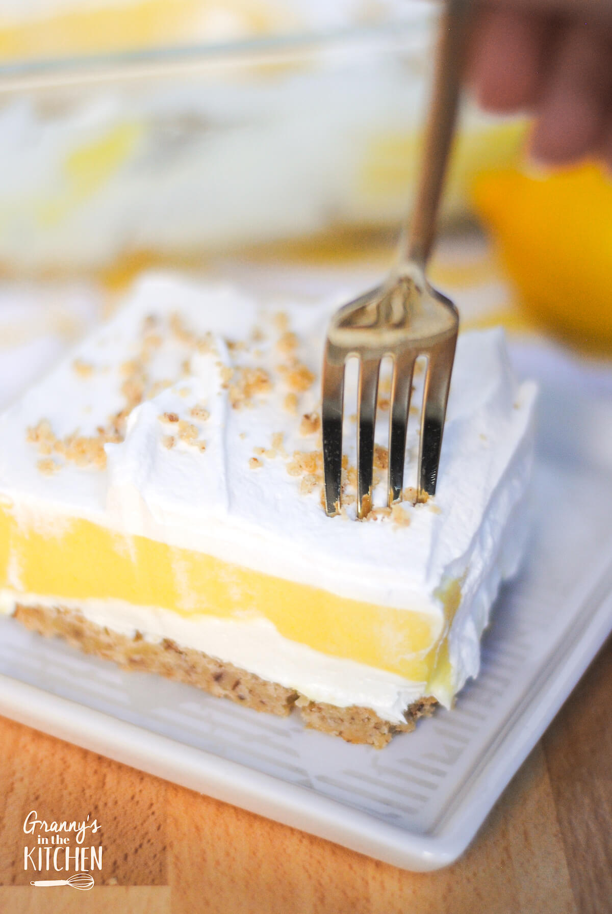 fork in layered lemon dessert slice.