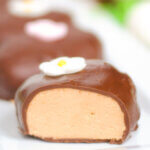 close up of a chocolate covered peanut butter egg cut to show filling.
