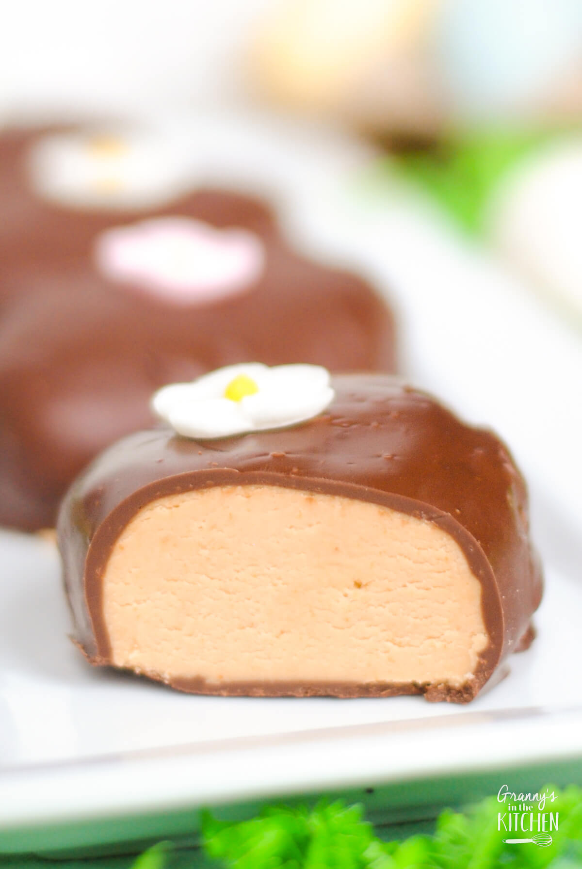 close up of a chocolate covered peanut butter egg cut to show filling.