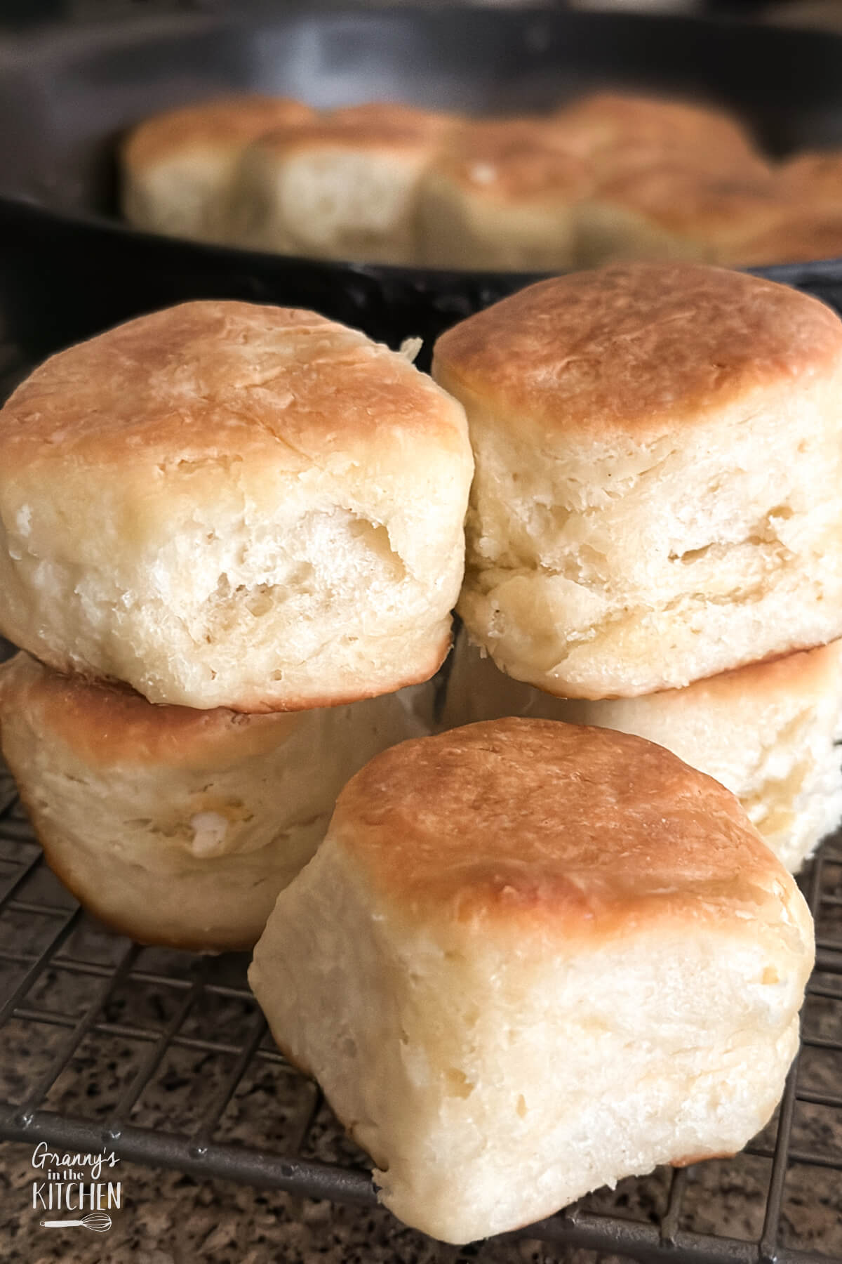 fluffy angel biscuits with iron skillet in background.