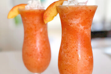 orange frozen drink in hurricane glasses; text overlay "Peach Fuzzy".