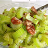bowl of cooked celery slices and pecans; text overlay "Sautéed Celery".