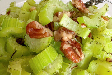 bowl of cooked celery slices and pecans; text overlay "Sautéed Celery".