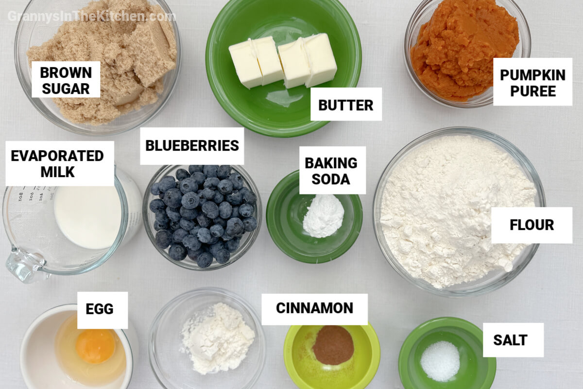ingredients to make pumpkin blueberry muffins, with text labels.